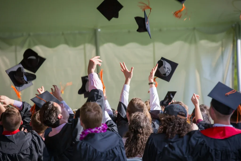 Group of graduates throwing caps in the air at a graduation ceremony
