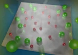 Energy transfer in material between atoms on a titanium dioxide catalyst surface visualized by red and green spheres