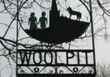 Village sign showing the green children of Woolpit, erected in 1977.