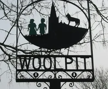 Village sign showing the green children of Woolpit, erected in 1977.