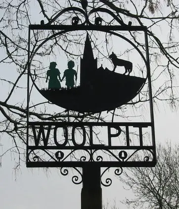 Village sign showing the green children of Woolpit, erected in 1977.